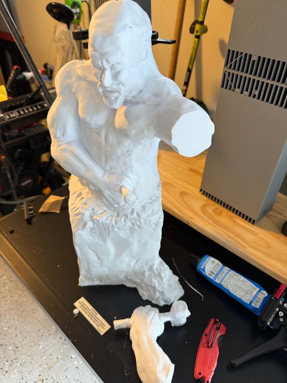 Large 3D printed white figure sculpture being assembled in the workshop