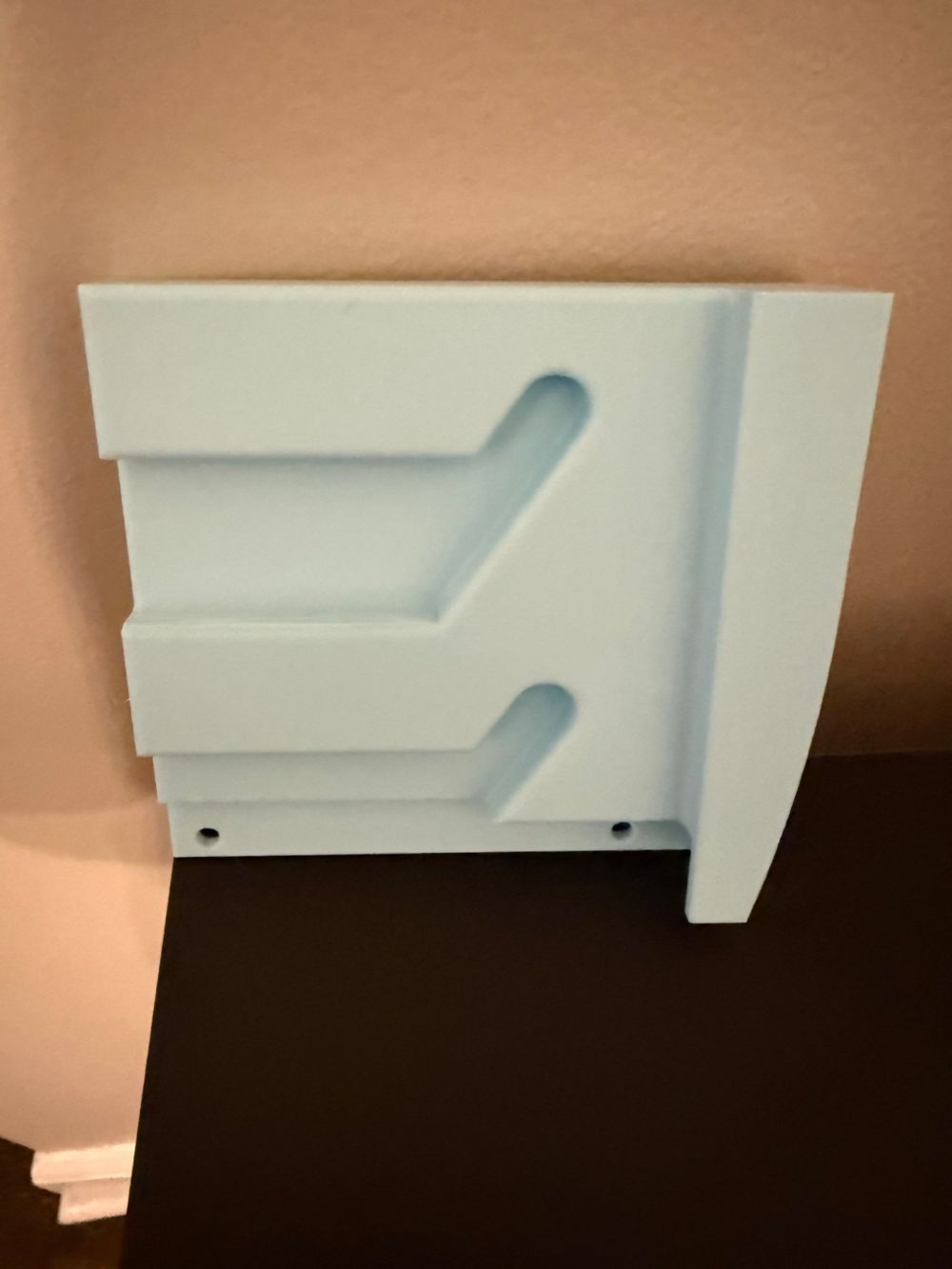 3D printed light blue wall-mount bracket with screw holes