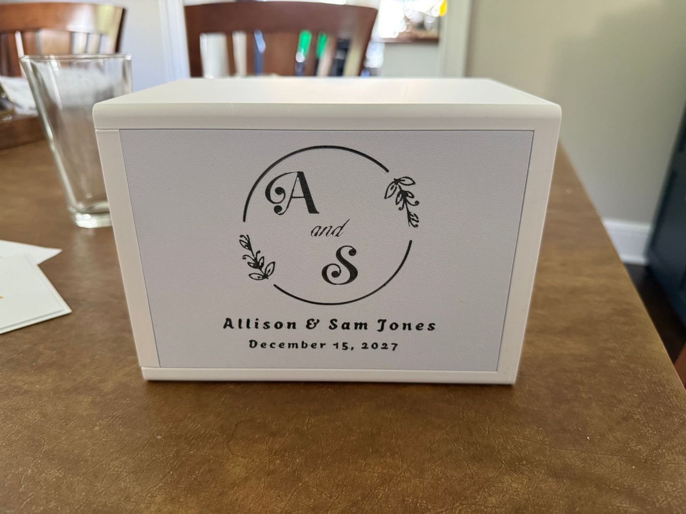 White 3D printed wedding card box with a black monogram and names on the front