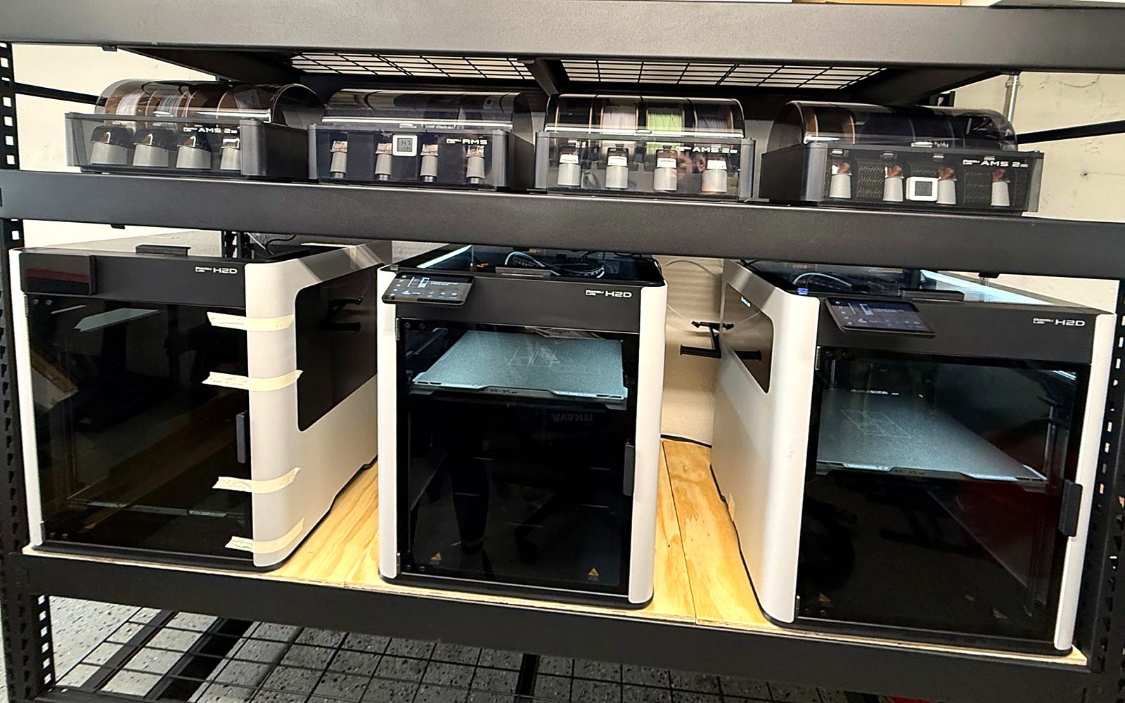 The 3D Print Live print farm: three Bambu Lab H2D printers with multi-material units